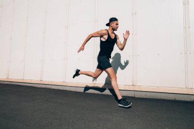 Hızlı sanayi kenti arka planda koşan koşucu adam. Spor, atletizm, fitness, etkinlik koşu