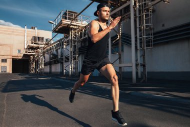Sportif adam hızlı sanayi kenti arka planda çalışan. Spor, atletizm, fitness, etkinlik koşu