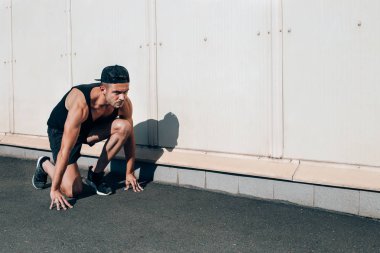 Genç adam yayınlanmaya başlar sokak şehir poz. Sprinter eğitim açık