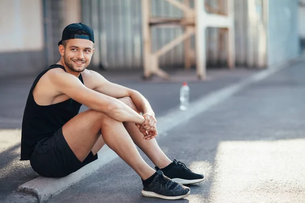 Bello Uomo Sorridente Corridore Riposo Dopo Allenamento Seduto Strada Città — Foto Stock