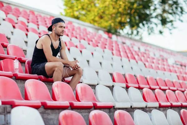 Hombre Deportivo Serio Auriculares Escuchando Música Sentado Asientos Tribuna Estadio —  Fotos de Stock