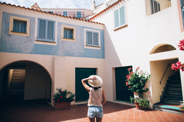 Young beautiful woman enjoy cozy Italy courtyard in Sardinia island. Europe travel vacation