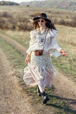 Doğa üzerinde yürüyen güzel genç boho kadın. Özgürlük yaşam tarzı