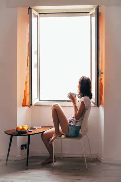 Jovem Mulher Bonita Bebendo Café Quente Sentado Perto Janela — Fotografia de Stock