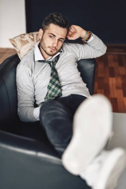 Yakışıklı hipster adam kanepe rahatlatıcı. dinlenme ve eğlence kavramı