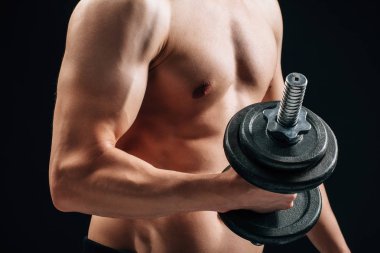 Kaslı vücut geliştirmeci adam dumbbell ile yapıyor. Spor kavramı