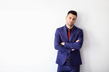 Beyaz arka plan üzerinde çapraz kolları olan genç emin iş adamı