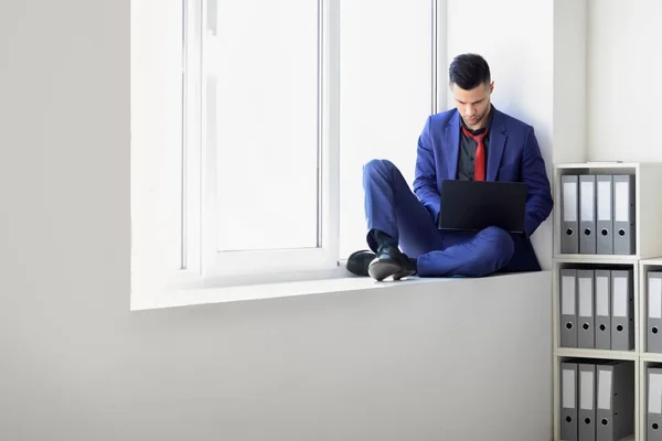 Zakenman Man Aan Het Werk Met Laptop Zitten Vensterbank Kantoor — Stockfoto