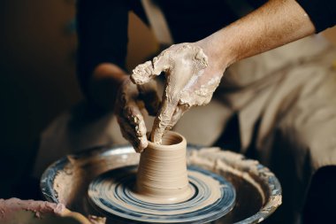 Çömlekçilik atölyesinde kilden seramik çömlek yapan çömlekçi çarkı üzerinde çalışan adam çömlekçi. sanat kavramı