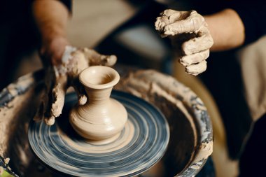 Çömlekçilik atölyesinde kilden seramik çömlek yapan çömlekçi çarkı üzerinde çalışan adam çömlekçi. sanat kavramı