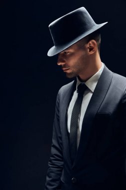 Profil görünümü portre oh siyah takım elbise ve şapka koyu arka plan üzerinde yakışıklı adam. Erkek güzellik konsepti                                         