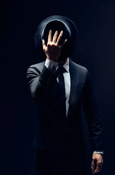 Homem Fato Esconder Cara Atrás Chapéu Isolado Fundo Escuro Conceito — Fotografia de Stock