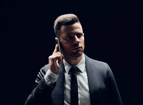 Bonito Homem Terno Preto Falando Telefone Celular Isolado Fundo Escuro — Fotografia de Stock