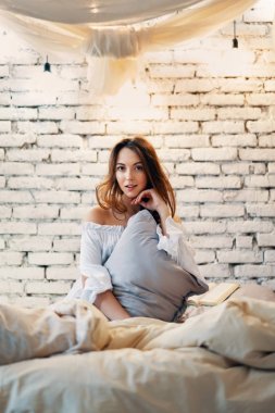 Modern bir dairede, yatak odasında poz veren güzel bir kadın. Tasasız konsept                                 