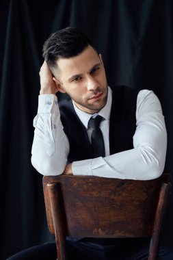Siyah arka planda kendine güvenen ciddi bir erkek portresi. Yakışıklı erkek kavramı