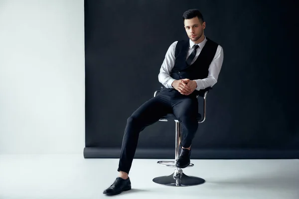 优雅自信的人摆姿势 坐在椅子上的黑白背景 成功理念 — 图库照片