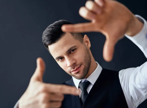 Knappe Elegante Man Zoek Door Een Vinger Frame Zwarte Achtergrond — Stockfoto