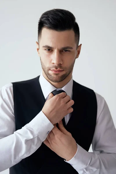 Young Handsome Man Elegant Suit Adjust His Necktie White Background — Stock fotografie