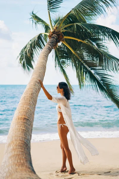 美しい女性はヤシの木の背景に熱帯の砂浜でリラックスします 夏休み 孤独なコンセプト — ストック写真