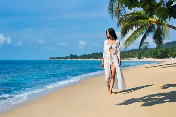 漂亮的年轻女子穿着白色比基尼赤脚走在热带海滩的海边 暑假和放松的概念 — 图库照片