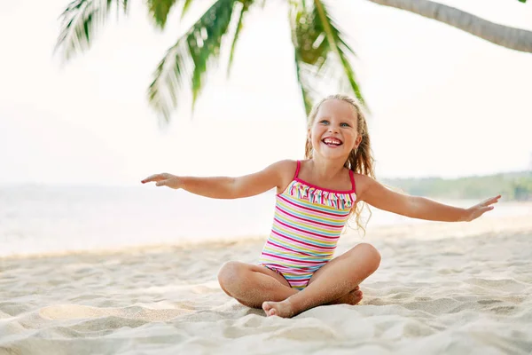 ヤシの木の下で砂浜で遊ぶ幸せなかわいい子供 夏休みと旅行のコンセプト — ストック写真