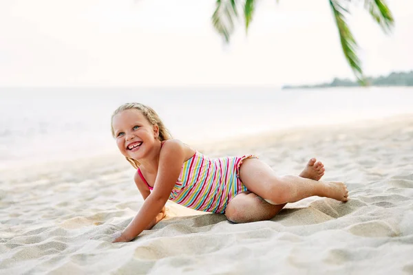 ヤシの木の下で砂浜で遊ぶ幸せなかわいい子供 夏休みと旅行のコンセプト — ストック写真