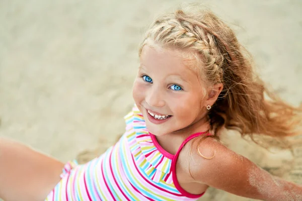 砂浜でリラックス愛らしい小さなブロンドの女の子 — ストック写真