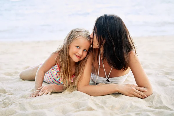 年轻女子亲吻小女儿放松在热带海滩在暑假 — 图库照片