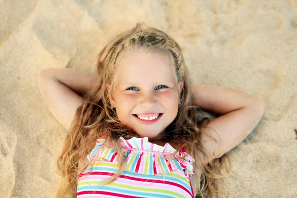 漂亮的小金发女孩的肖像躺在沙滩在暑假期间 海放松 快乐的童年概念 — 图库照片