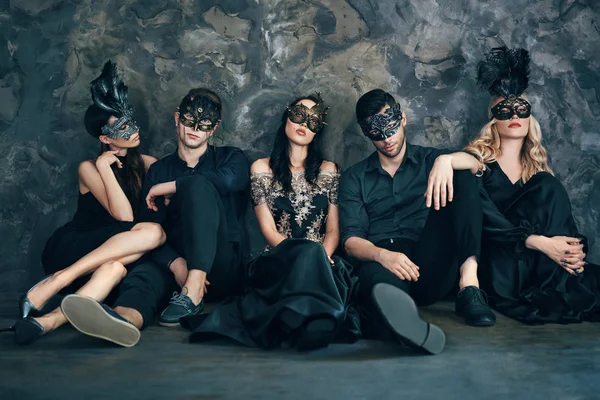 Ομάδα Των Φίλων Μασκέ Απόκριες Μάσκες Κάθονται Στο Πάτωμα Χαλαρωτικό — Φωτογραφία Αρχείου