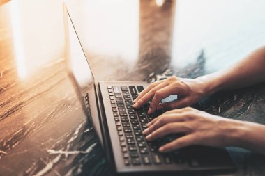 Güneş ışığı ile masada dizüstü bilgisayarda yazarak kadın elleri çekim kapatın