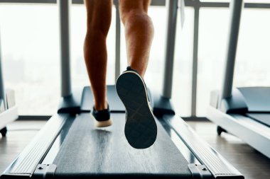Spor salonunda koşu bandıüzerinde çalışan spor ayakkabı erkek kaslı ayakları kapatın