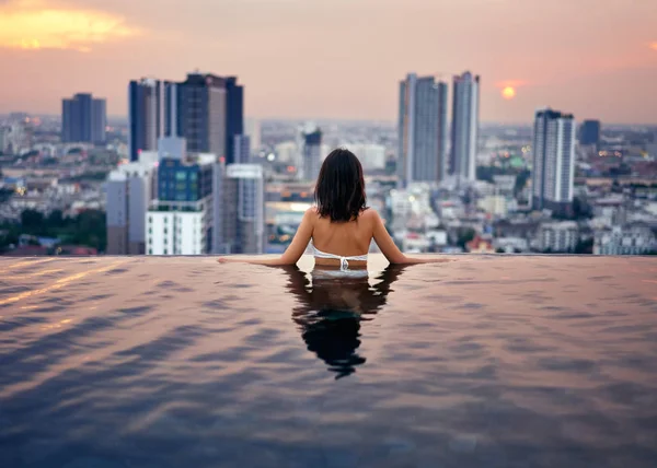 Vista Trasera Mujer Relajándose Piscina Azotea Durante Increíble Atardecer —  Fotos de Stock