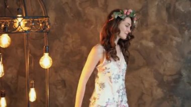 dans eden genç, zarif bir kadın pijama ve çiçek tacıyla