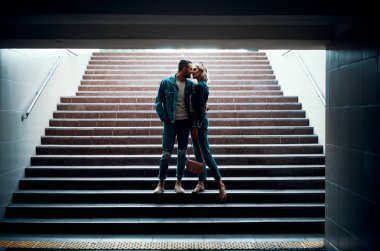 Şehvetli çift yer altında öpüşüyor.