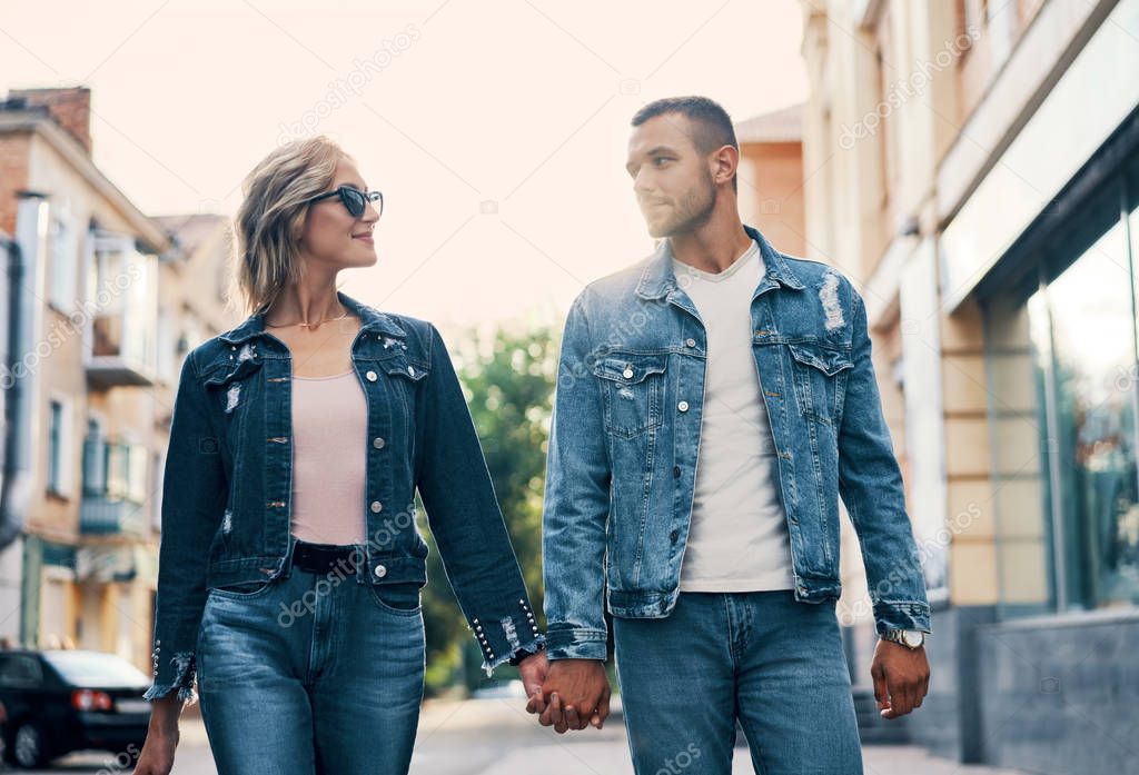 Young loving couple walking together holding hands