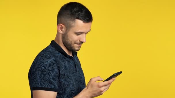 Joven Usando Smartphone Sonriendo Sobre Fondo Amarillo — Vídeos de Stock