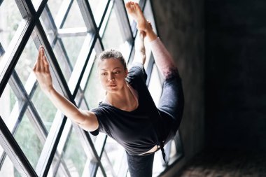 Pencerenin arkasında yoga yapan güzel bir kadın var..  