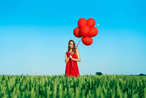 Mujer Joven Vistiendo Vestido Rojo Pie Campo Verde Con Globos — Foto de Stock