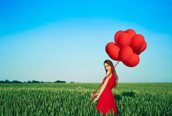 Young Woman Wearing Red Dress Standing Green Field Red Balloons — Stock Photo, Image