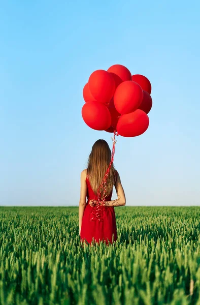 フィールドに赤い風船の女性のリアビュー — ストック写真