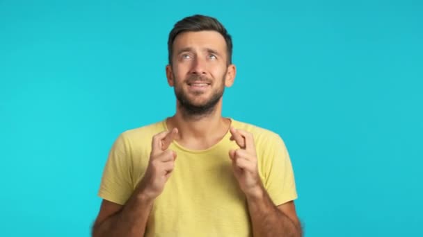 青い背景にポーズをとる若い髭の男 — ストック動画