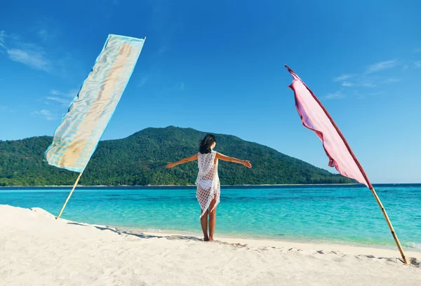 Młoda kobieta z rękami w górze zrelaksować się i cieszyć turkusowe morze na tropikalnej plaży w rajskiej wyspie — Zdjęcie stockowe