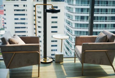 Şehir manzaralı büyük pencerenin yanındaki koltuklar