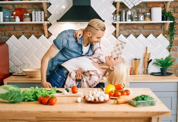 Heureux jeune couple amoureux dansant dans la cuisine à la maison et s'amusant — Photo