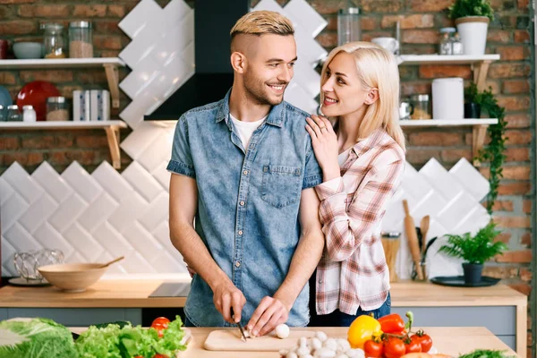 Sourire jeune couple cuisiner ensemble repas végétarien dans la cuisine à la maison — Photo