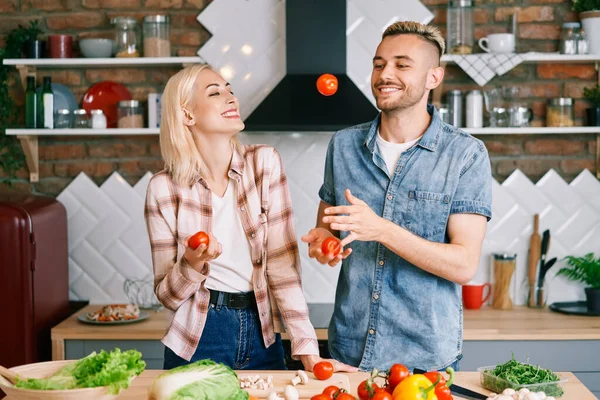 Heureux couple souriant s'amuser à cuisiner ensemble dans la cuisine — Photo