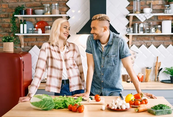 Sonriendo joven pareja cocinar juntos en la cocina en casa —  Fotos de Stock