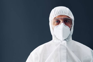 Siyah arka planda kopyalama alanı olan koruyucu giysili doktor.