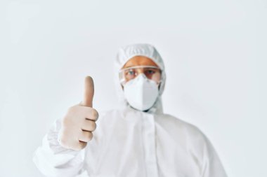 Koruyucu giysili doktor onaylıyor. Eline odaklan.